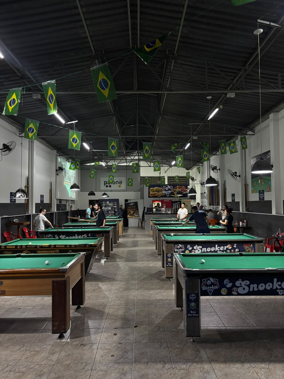 Mesa de sinuca com a logo do clube na parede